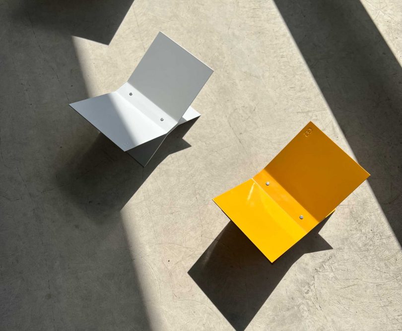 view looking down at two metal bookstands on concrete