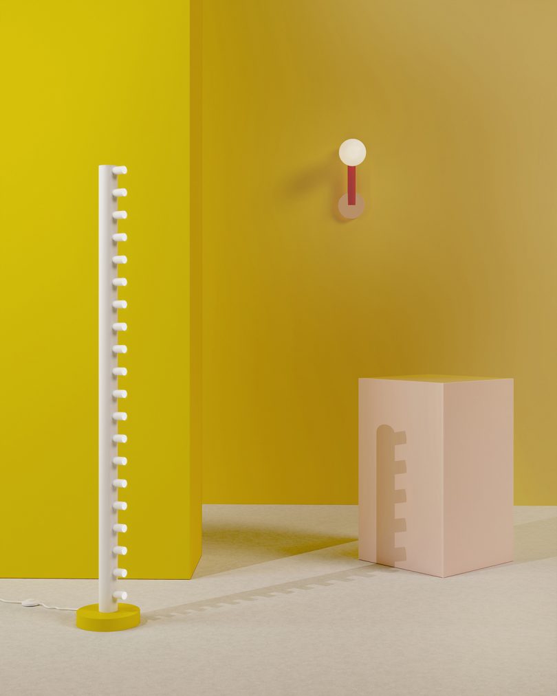 styled space with yellow walls, floor lamp, wall sconce, and white plinth