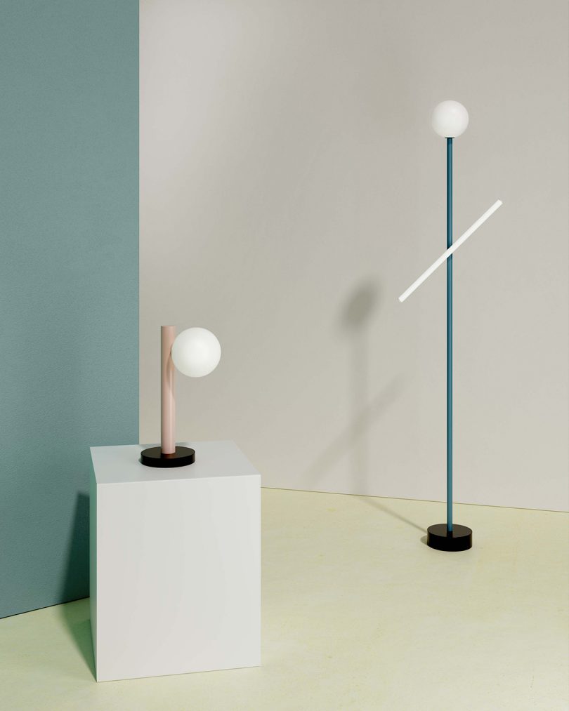 styled space with white and light blue walls, floor lamp, table lamp on white plinth