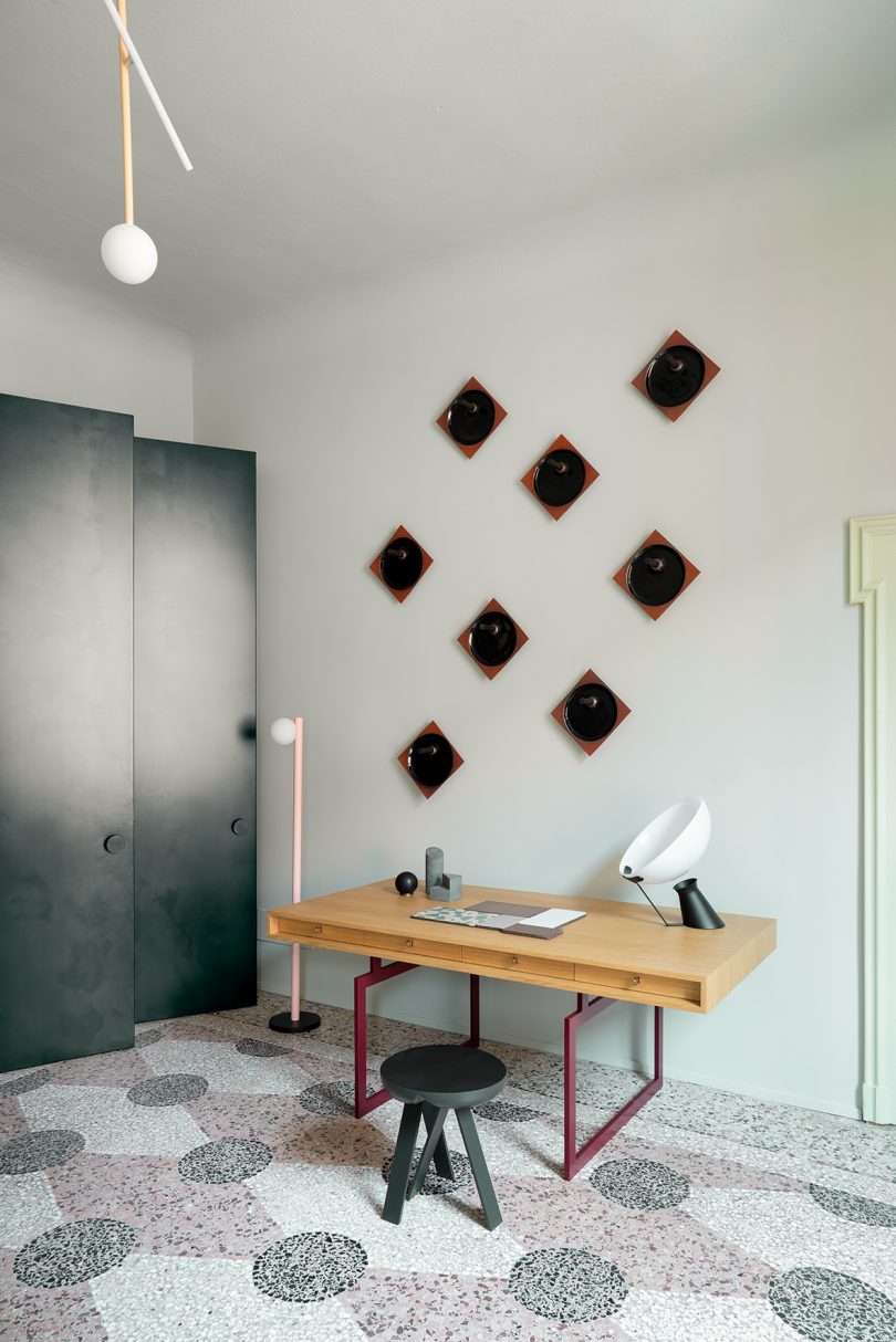 stylish interior space with desk, floor lamp and wall art