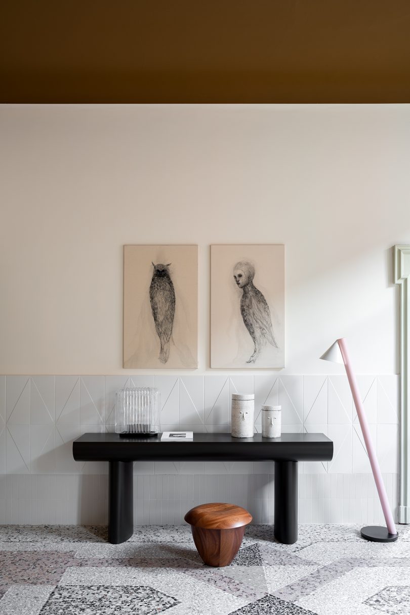 styled interior space with console table, wall art, and floor lamp