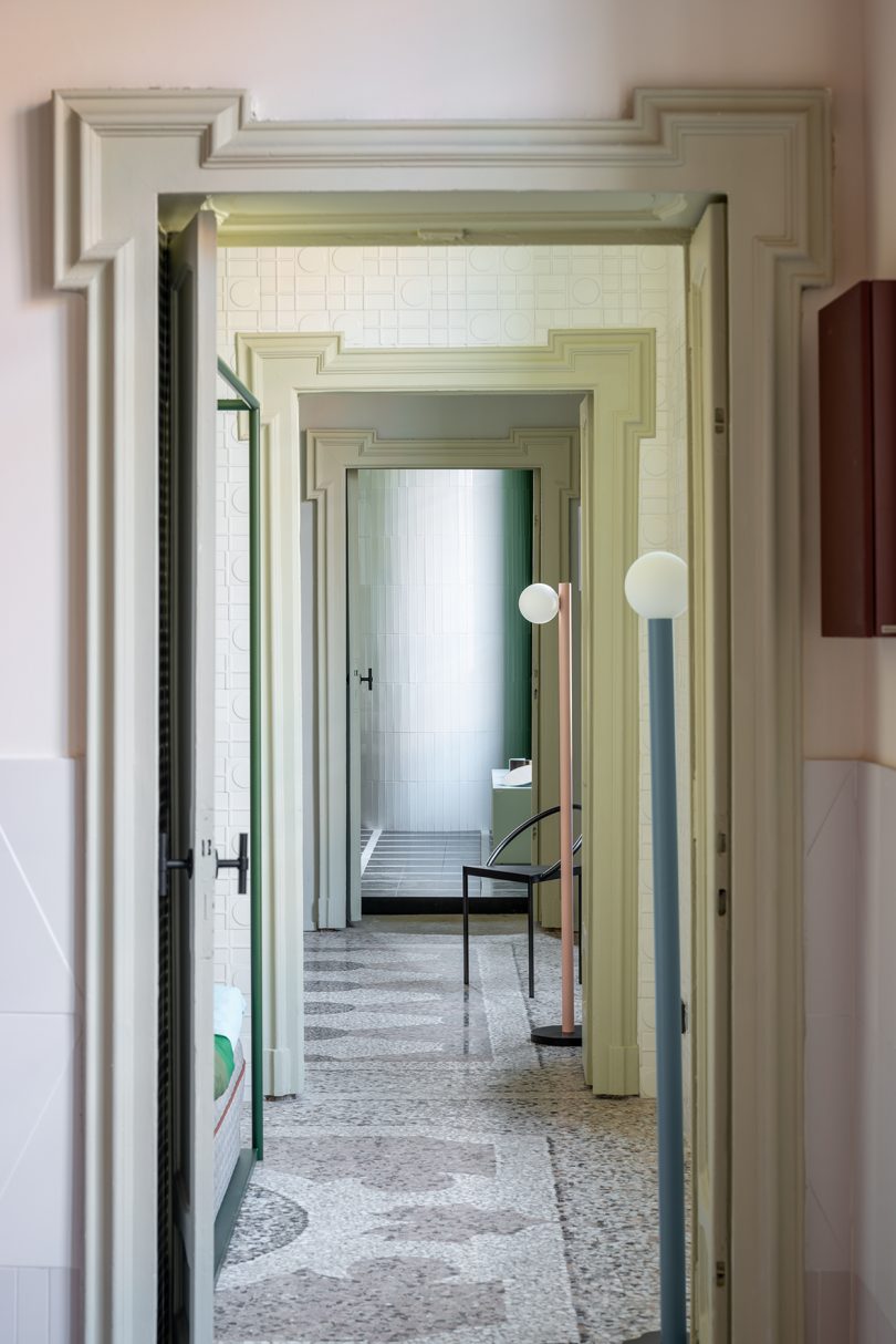 looking down a hallway through several open doorways with two floor lamps