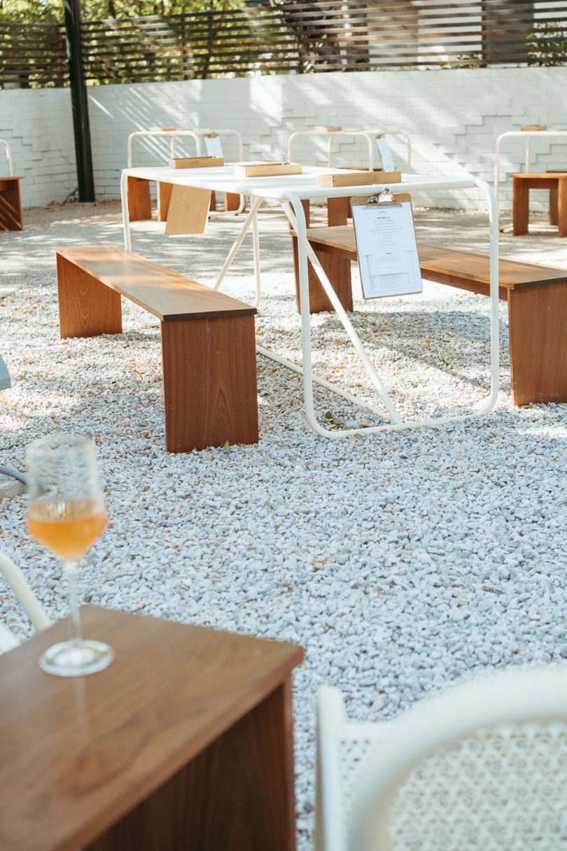 outdoor space with tables and benches sitting on top of gravel