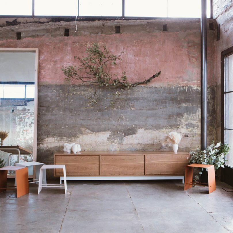 long, low wood console in front of a large wall mural