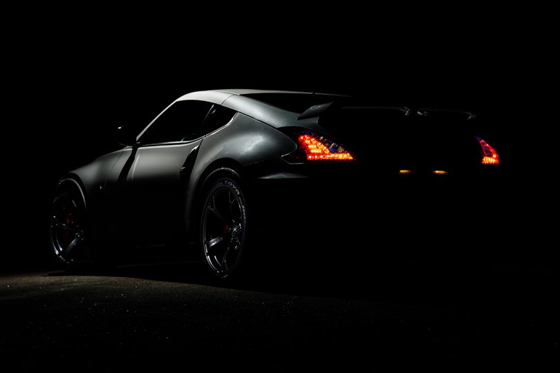rear of black sports car against black background