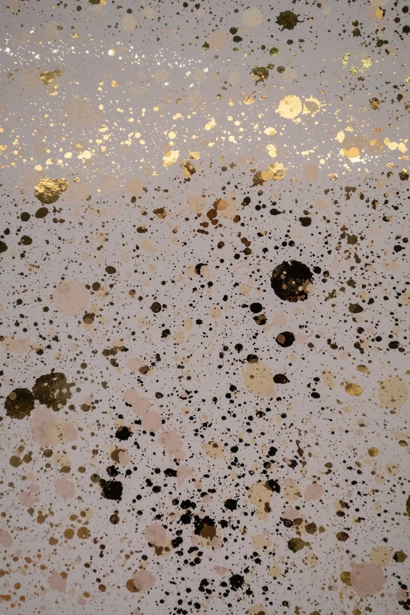 interior closeup view of metallic splattered wallpaper in gold tones