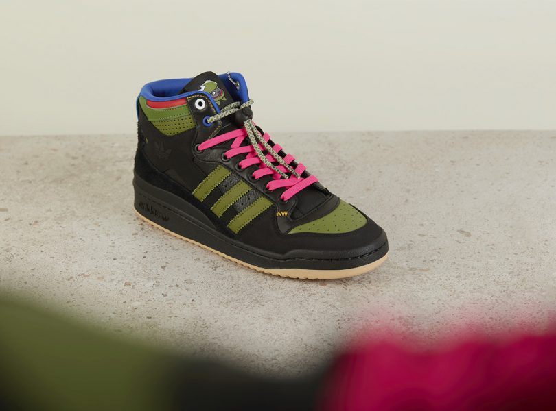 adidas Forum High Hebru Brantley side angle view, in black and olive colorway with hot pink laces.