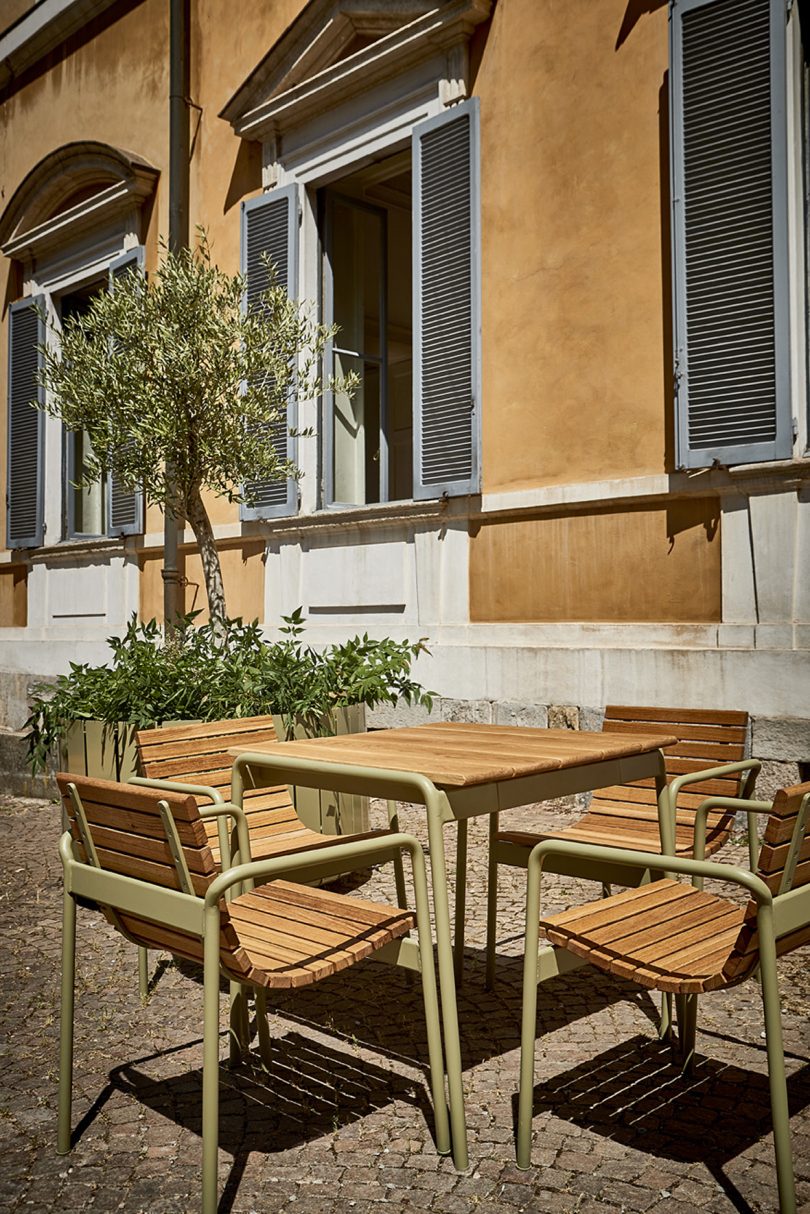 outdoor cafe table and four armchairs in a muted outdoor area