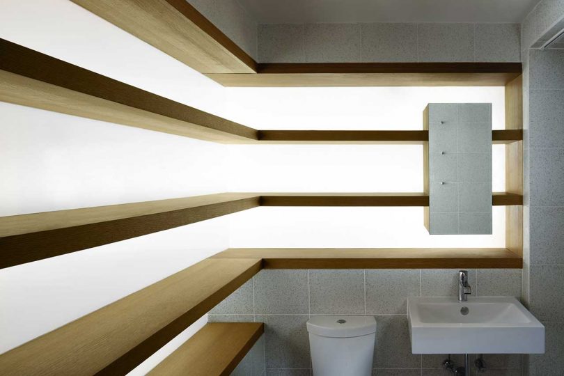 interior view of modern bathroom with L-shaped wood shelves with backlights