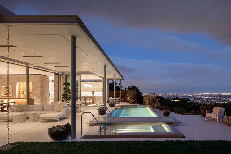 outdoor view of modern home's backyard with pool overlooking city