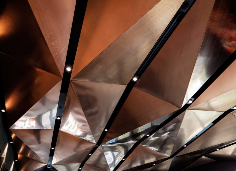 looking up at faceted metallic ceiling in serena williams building at nike
