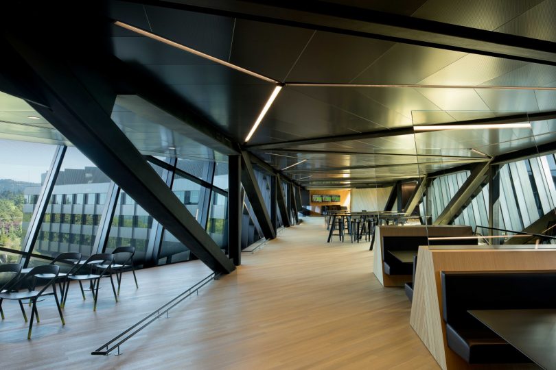interior office view with wood floors and dark ceilings and slanted beams with various types of seating