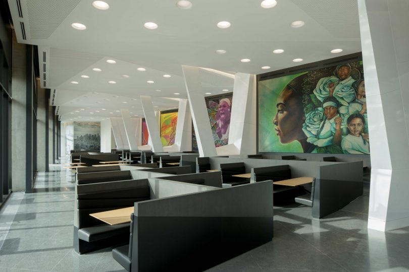 modern office interior with booth seating and Serena Williams murals painted on walls