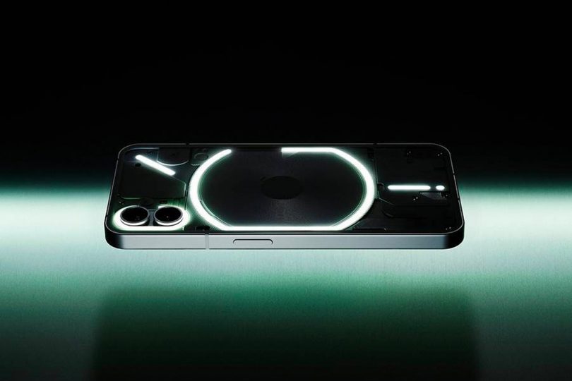 Nothing Phone 1 placed upon green and white glowing table with black backdrop.