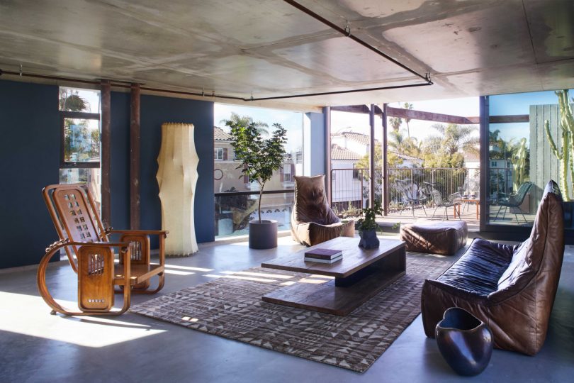 top floor interior view of modern house with eclectic furnishings looking out to rooftop deck