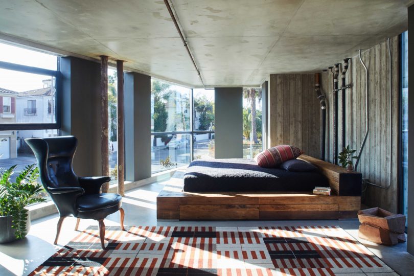 interior of open modern bedroom with modern minimalist furnishings and angled windows