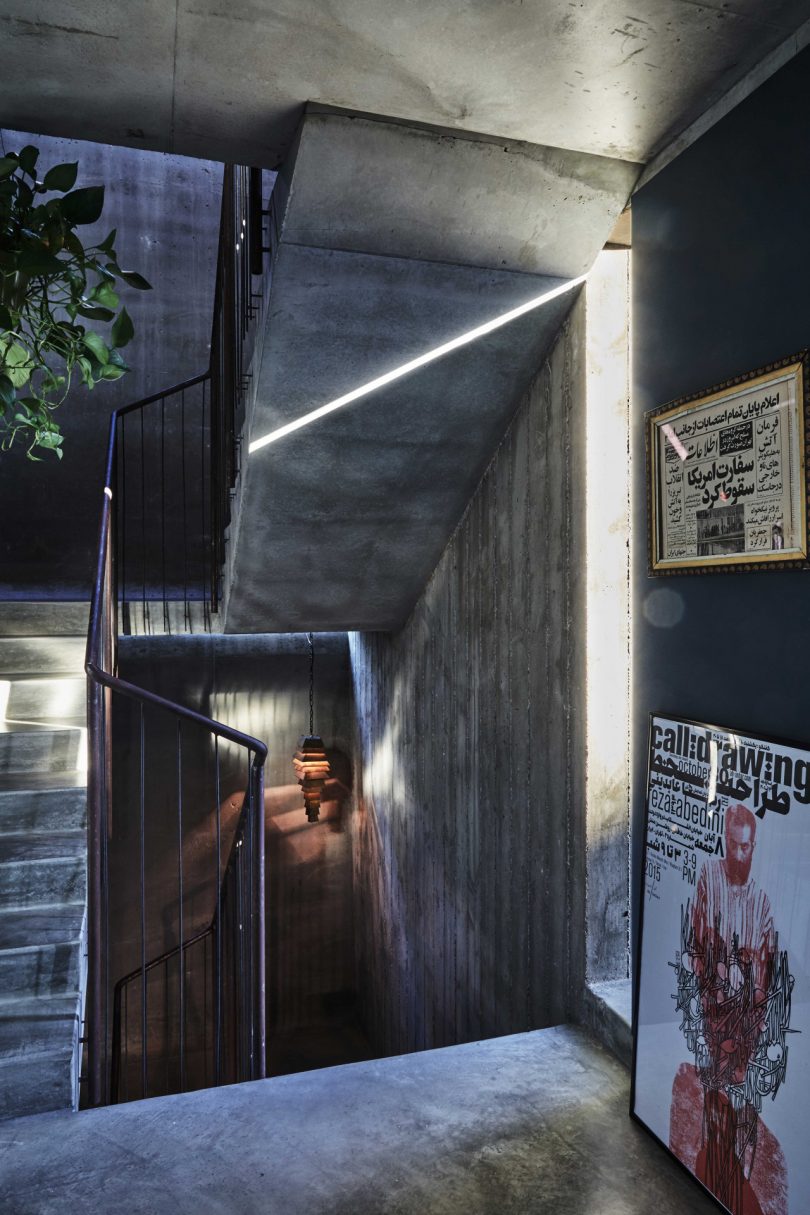 interior concrete staircase with concrete surfaces and artwork on walls