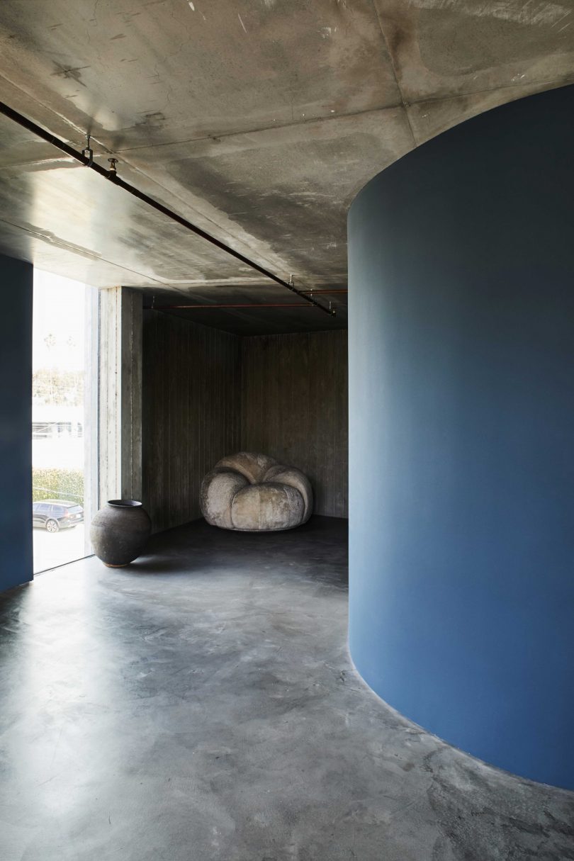 interior view of modern home with blue curved wall and concrete floors