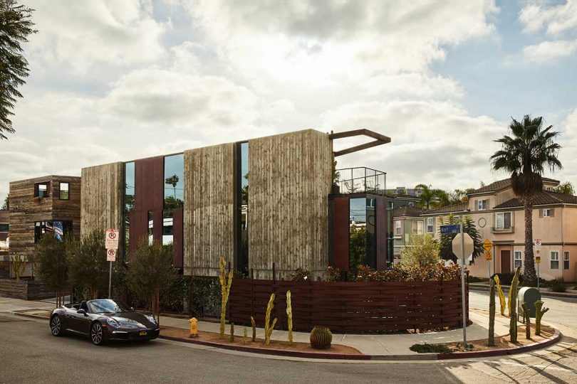 exterior side view of modern industrial house with rust red fence