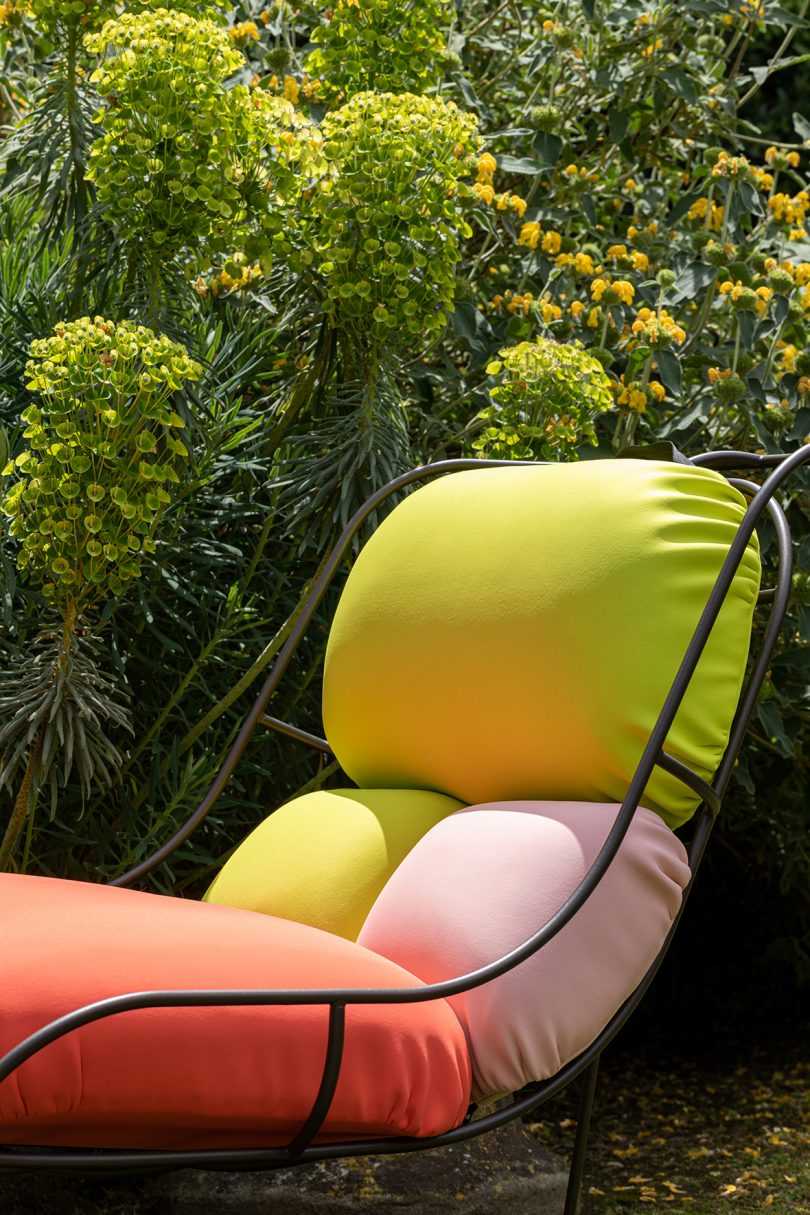 detail of wire framed chair with colorful cushions outdoors