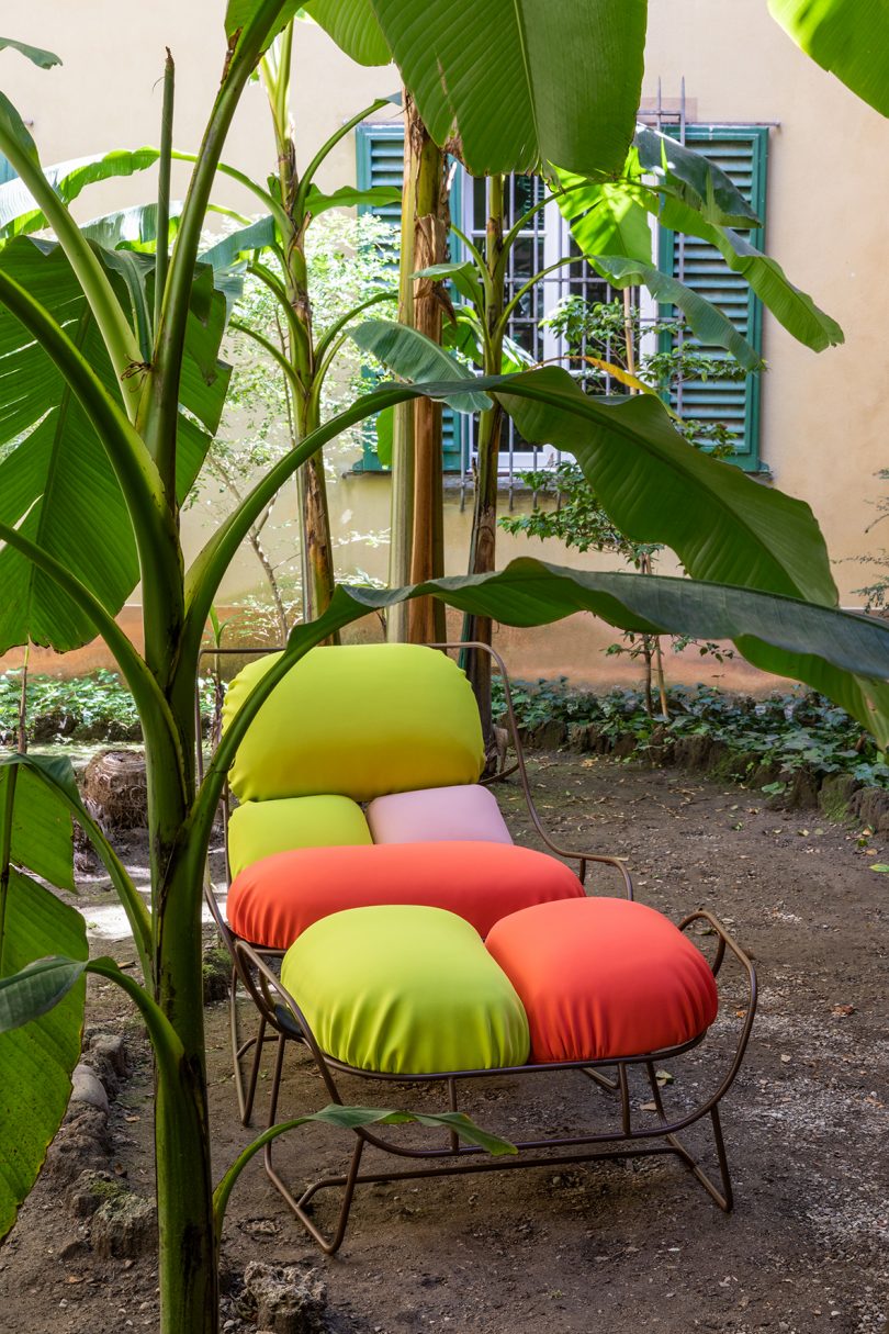wire framed chair with colorful cushions outdoors