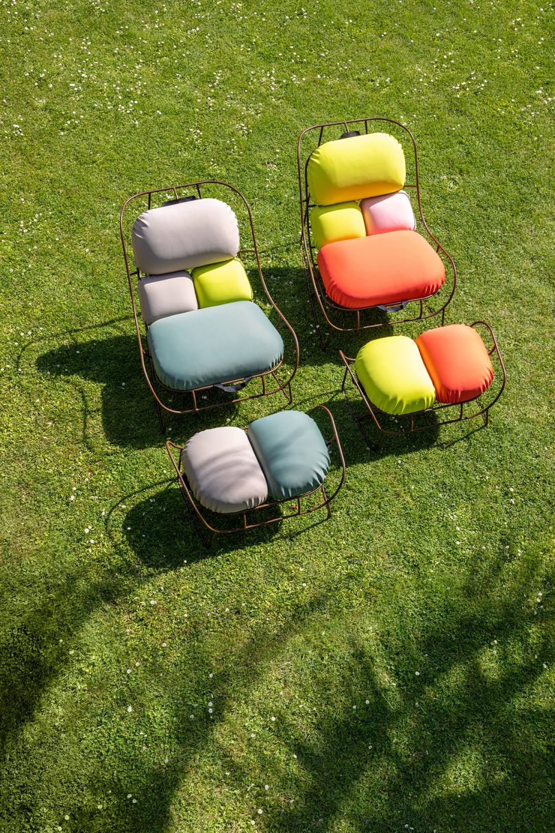 two wire framed chairs with colorful cushions outdoors