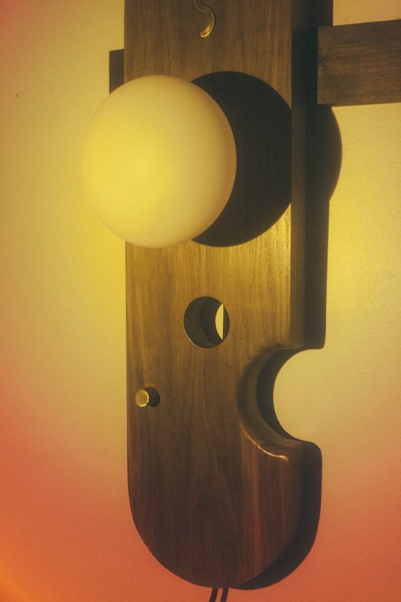 detail of illuminated abstract lamp with wood hanging on a wall 