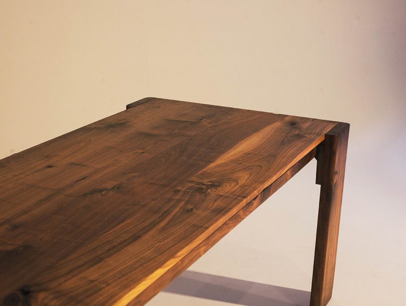 rectangular four legs dark wood table with brass details