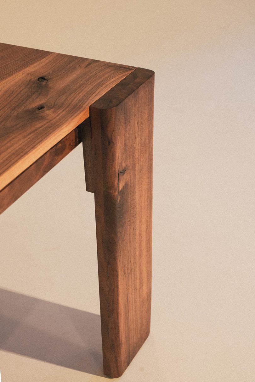 detail of rectangular four legs dark wood table with brass details
