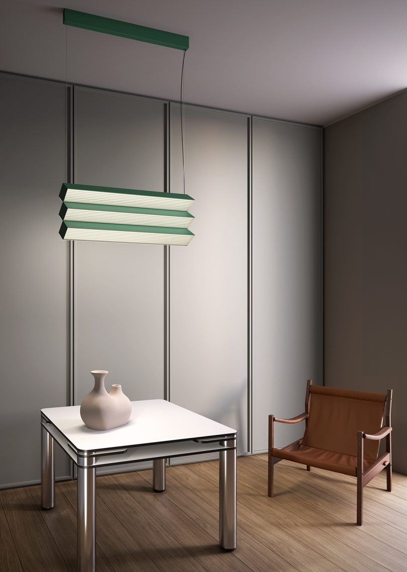 table and armchair with green overhanging light fixture