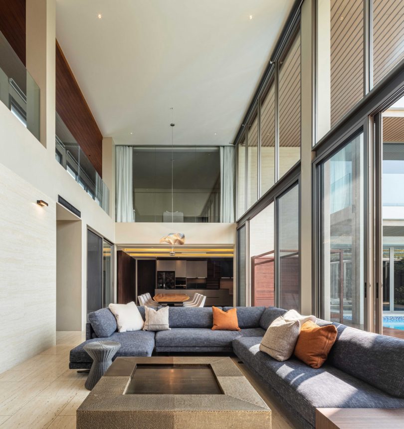interiérový záběr moderního obývacího pokoje s dvojitou výškou a pohovkou ve tvaru l