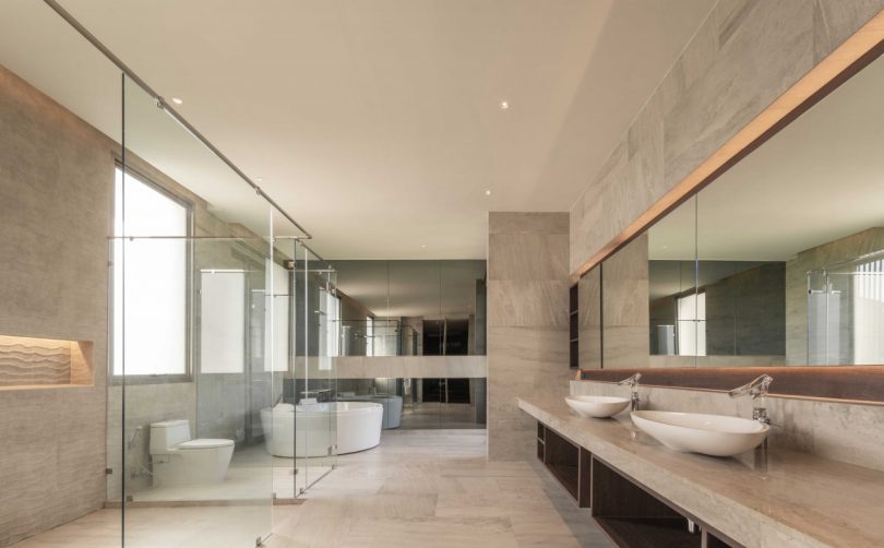 large, modern bathroom with tiled floors and neutral accents