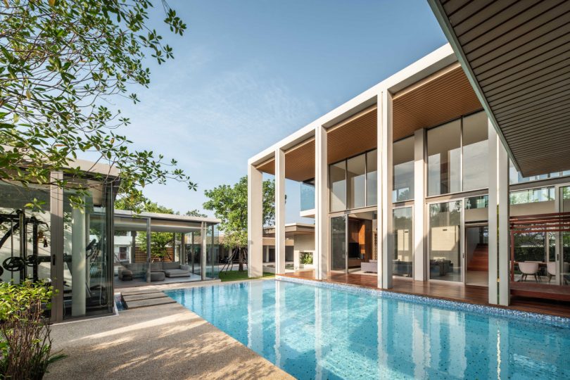 courtyard view angled of large modern Thai house with blue pool