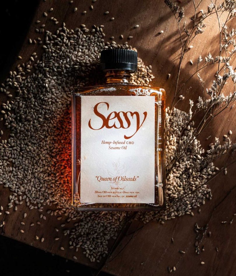bottle of dark sesame oil laying on pile of sesame seeds