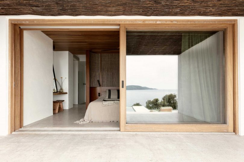 outdoor view looking into modern bedroom with sliding glass door open