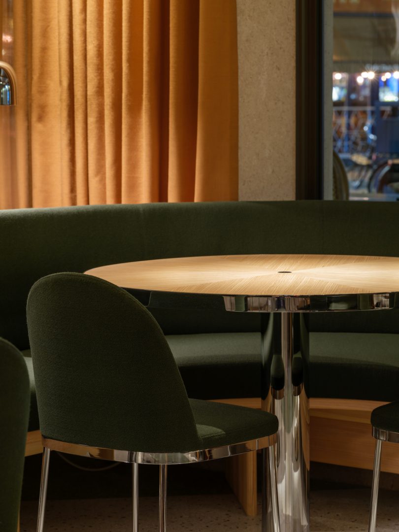 closeup restaurant view of round dining table with dark green seating