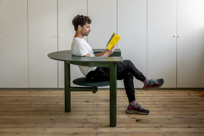 man in swivel arm chair reading