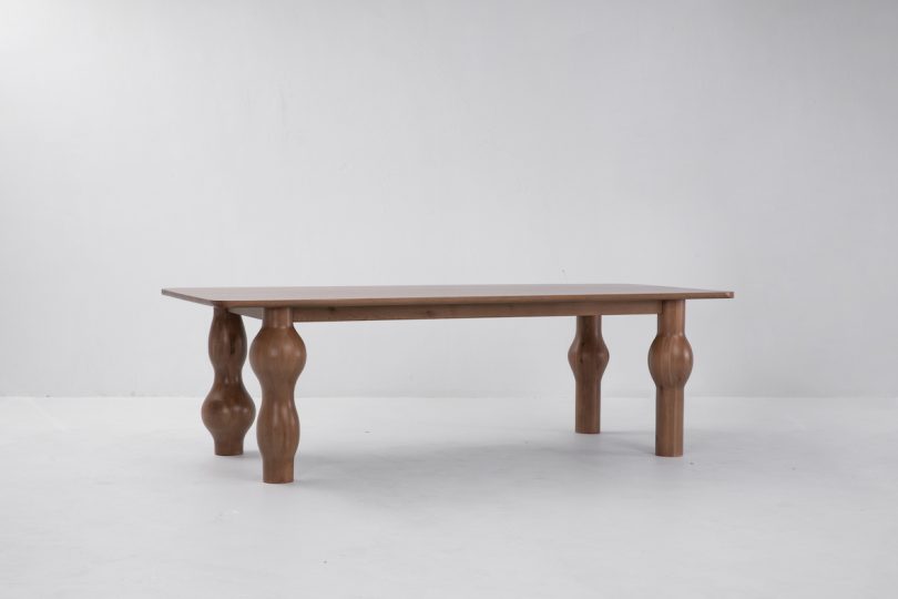 side view of dark wood dining table with unique bulbous legs