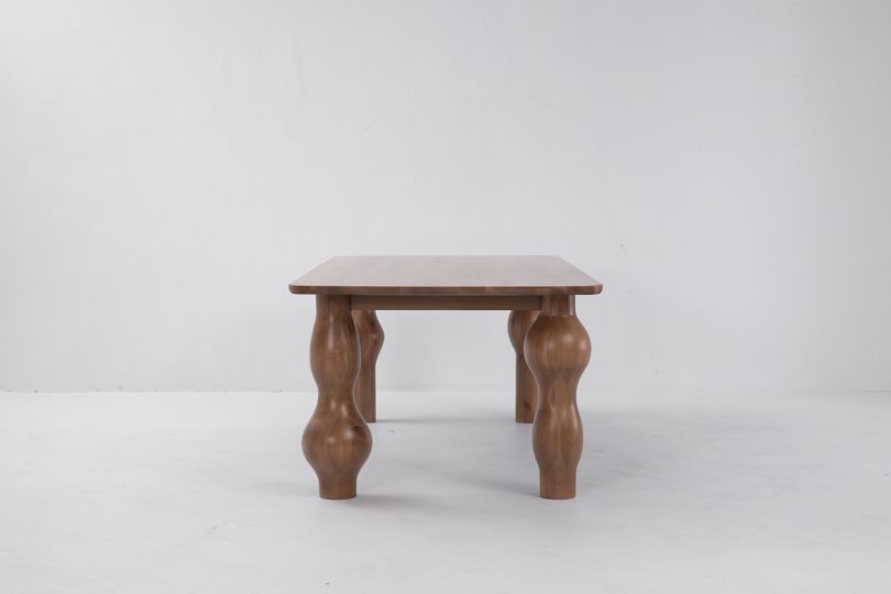 end view of dark wood dining table with unique bulbous legs