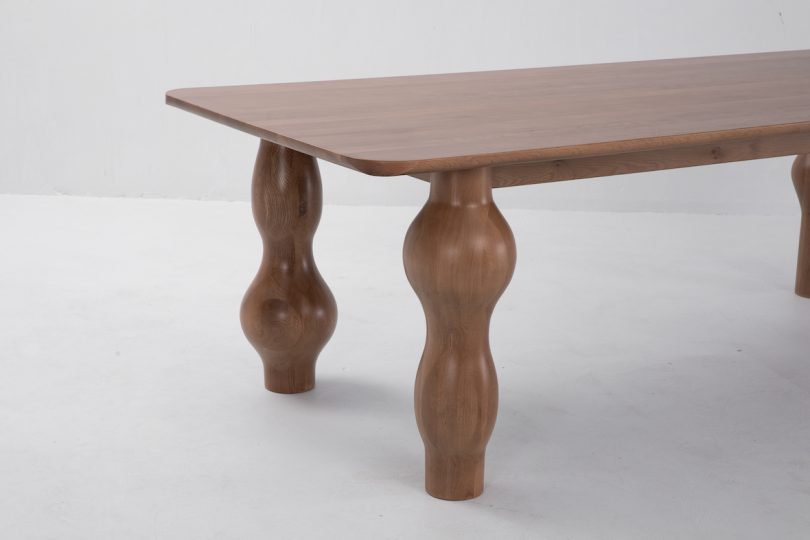 closeup side view of dark wood dining table with unique bulbous legs