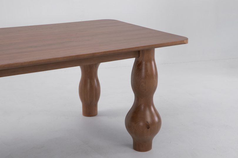 closeup end view of dark wood dining table with unique bulbous legs