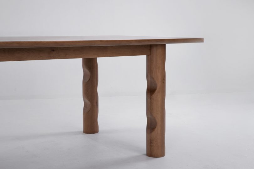 closeup view of dark wood dining table with wavy legs