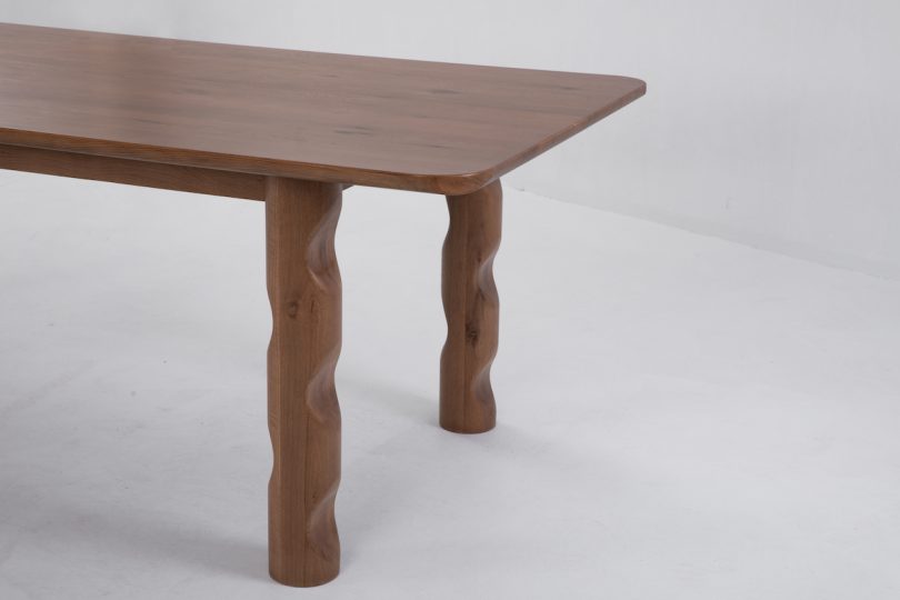 side end view of dark wood dining table with wavy legs