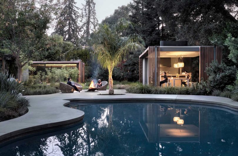 twilight exterior view of two pavilions and a pool surrounded by nature