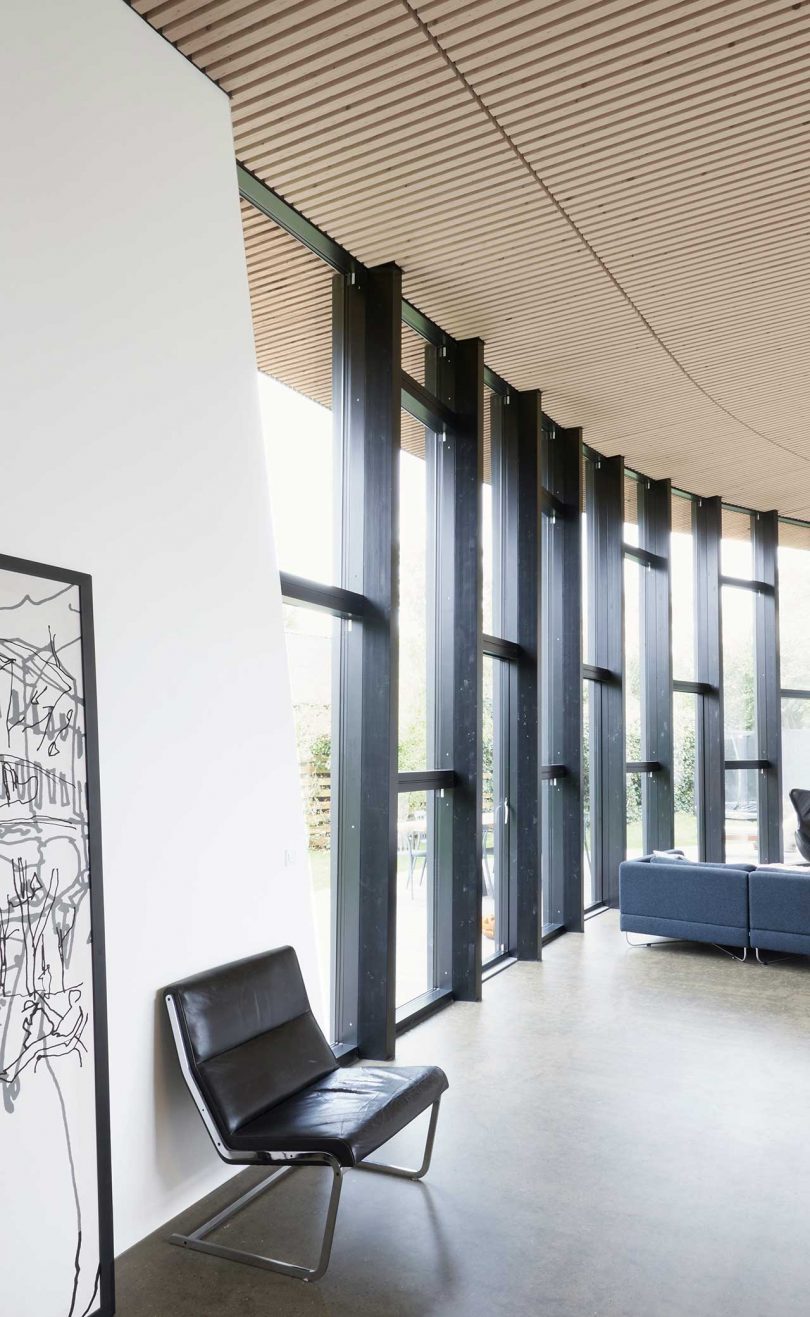 interior view of modern house's wall of curved windows framed in black