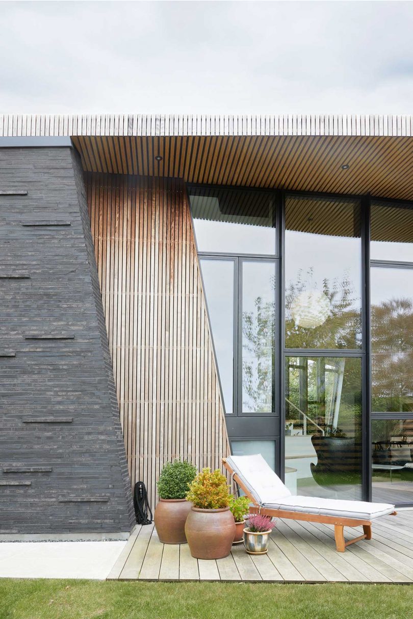 Closeup exterior view of modern house made of gray stone and wood panels