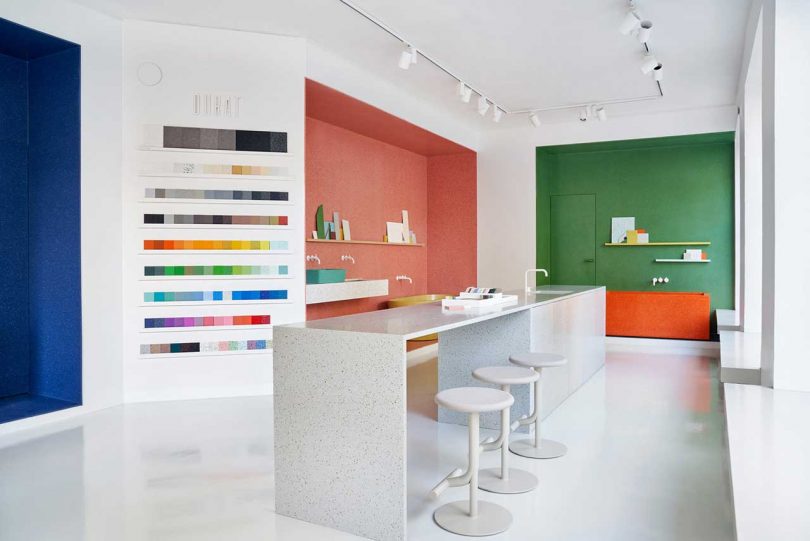 interior view of showroom with colorful vignettes showcasing various surface material products