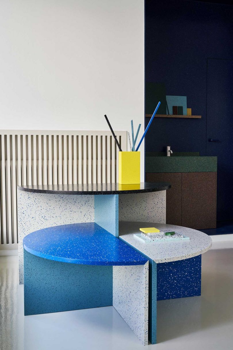 showroom interior shot of modern table with stools in varying colorful surface materials