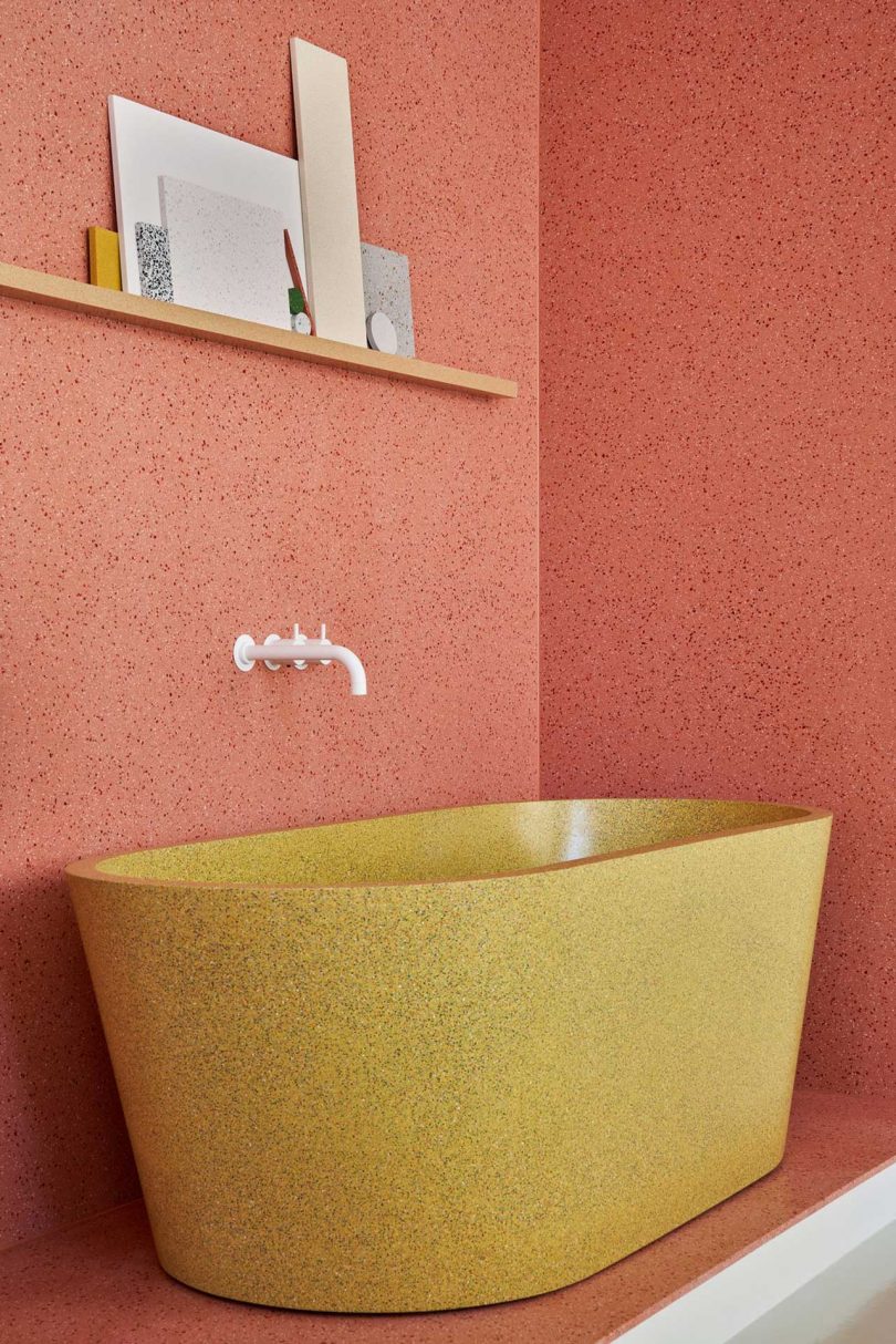 interior of showroom with closeup of gold tub in front of pink wall