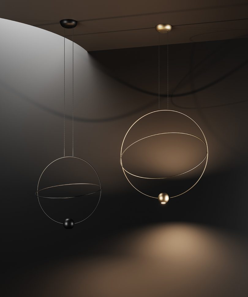 two large orbit-like suspension lamps hang against a black background